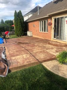Stamped Concrete Patio with Red Paint in Macomb Twp., Before Stripping